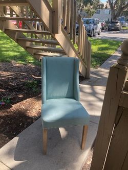 Comfortable blue upholstered chair with wooden legs.