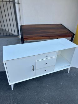 White TV stand, a TV and a table.
