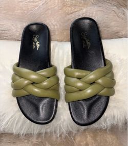 sandalias son las Seychelles "Low Key" en color verde oliva, caracterizadas por sus correas acolchadas y entrelazadas.
