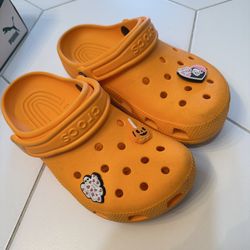 Orange crocs. Size 4 men, size 6 women. With charms.