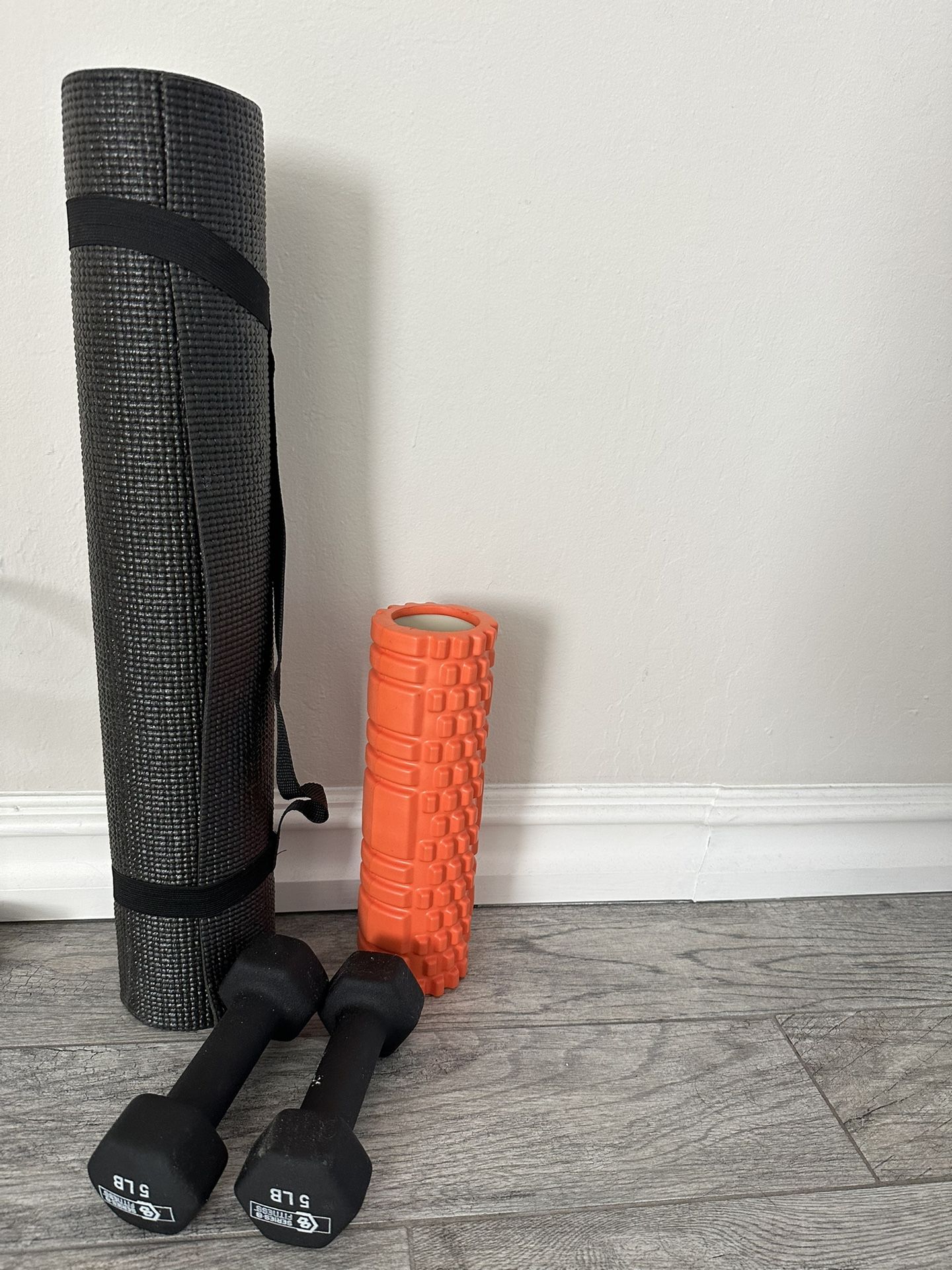 Yoga mat, foam roller and dumbbell
