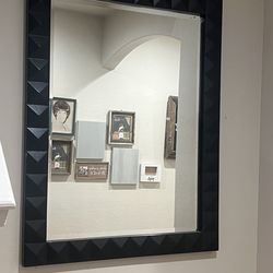 Studded Mirror has an updated appeal to a timeless design featuring a 3-dimentional pattern finished in a sleek matte black. May be hung horizontal or