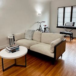 Castlery Cane Sofa With Black Trim And Beige Cushions 