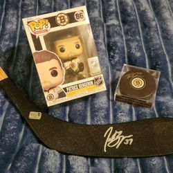 Boston Bruins Brad Marchand Autographed Puck And Adidas Jersey + Patrice Bergeron Autographed Stick And Funko