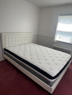 White faux-leather platform bed frame with amattress / queen