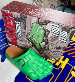 These are Bravest Studios Green Hulk Foot Clogs, featuring a molded green design with an adjustable metal buckle.