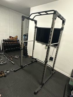Squat rack with one Olympic squat bar and clips.