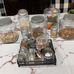 All Bottle Or Glass Jars on the table and the thing Holding the candle