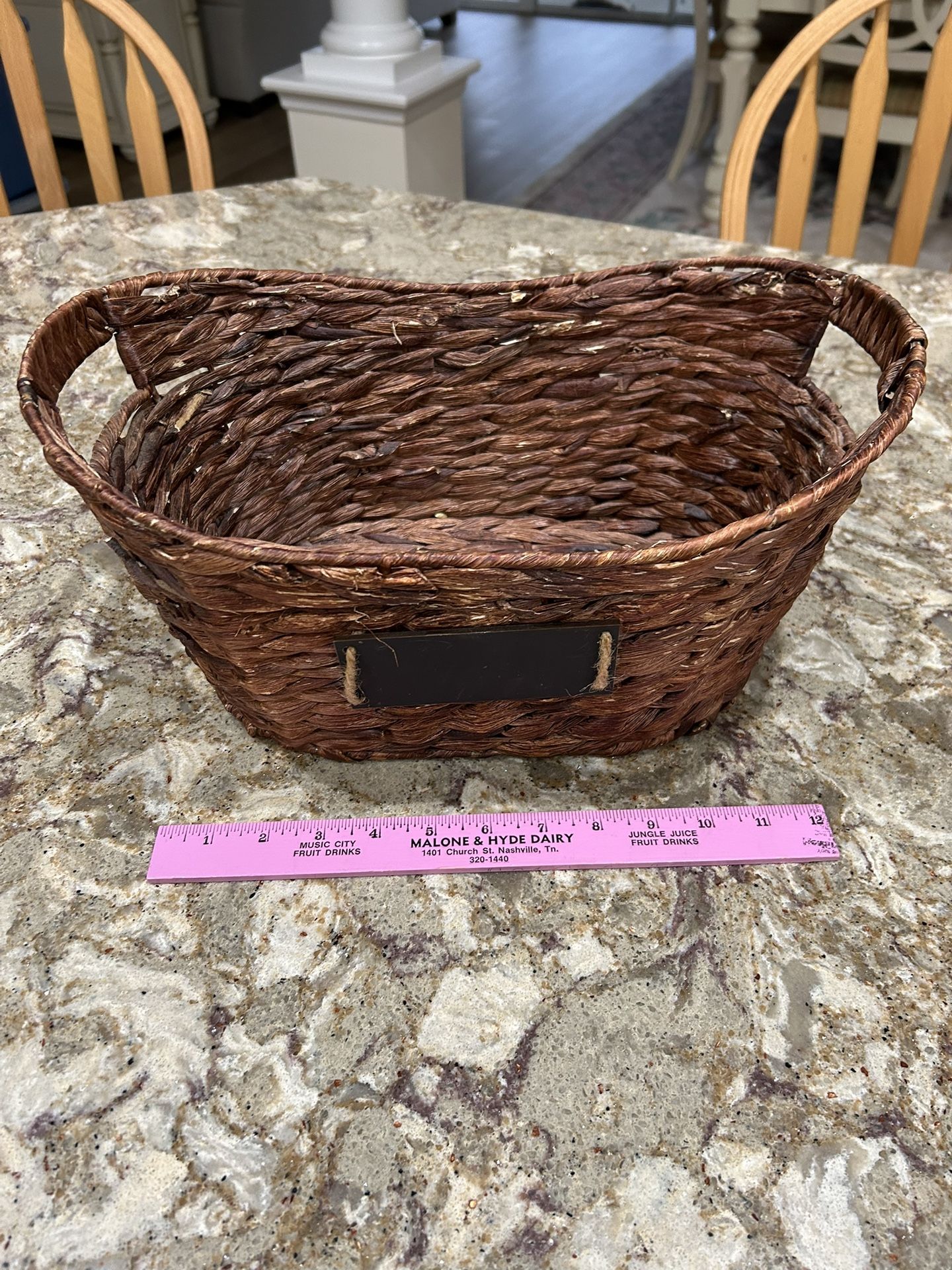 Brown woven basket with handles, approximately 12 inches long