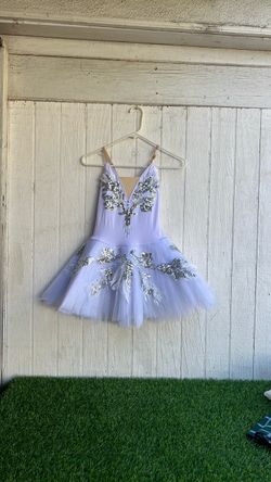vestido de tutú de ballet de color blanco que destaca por sus vistosos apliques de lentejuelas plateadas en la falda de tul.