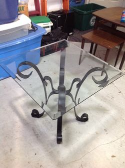 End table with ornate metal base and glass top