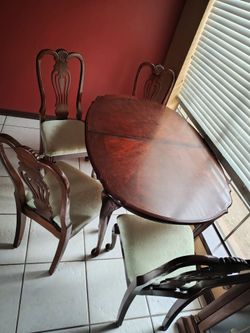 cherry wood oval table with Queen Anne style legs and six chairs