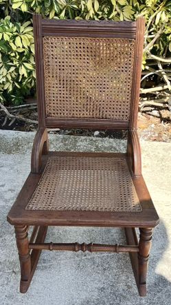 Antique Victorian Wooden rocking chair 1890s with a cane seat and back.