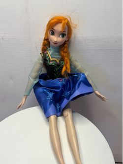 Anna doll from the Disney animated film *Frozen*. Judging by her articulated limbs and costume details, this is a singing doll—standing approximately 