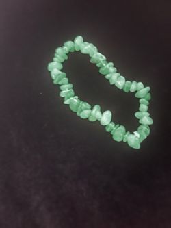 Natural green stone Emerald chip bracelet with an elastic band. This piece is made of irregular polished green stone nuggets and has a stretchable des