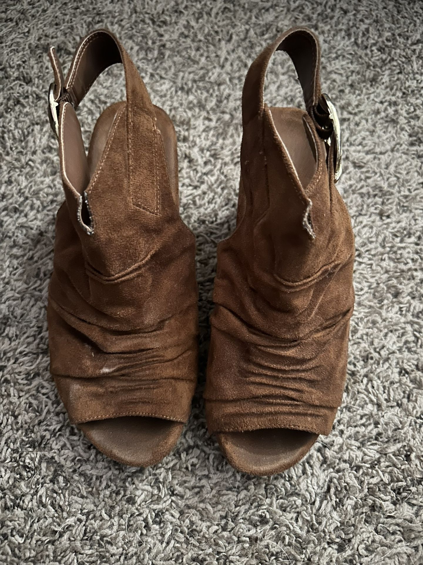 brown suede open-toe slingback booties with a ruched front and a large buckle strap on the side