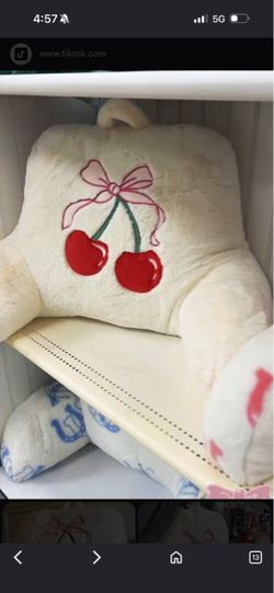 reading/backrest pillow featuring an embroidered red cherry and pink bow design.