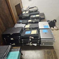  100 used laptops, consisting of a mix of Lenovo ThinkPads and Apple MacBooks.