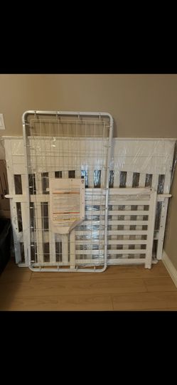 disassembled convertible wooden baby crib (in white).