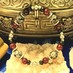 Obsidian Agit and Snowflake obsidian framed with silver colored fobs.
Medium size