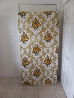 Vintage twin mattress with floral damask pattern