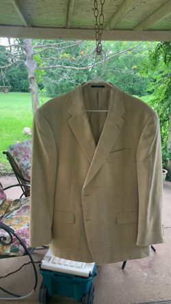 Paul Stuart suit jacket is styled with a subtle plaid pattern in a light tan color