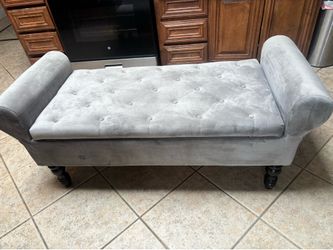 Grey velvet tufted storage bench with rolled arms