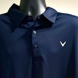 Size 2XL: Callaway Opti-Dri Performance Golf Polo Shirt in navy blue. It is a popular item designed for comfort and performance on the golf course. 