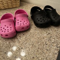 Black Pair And Pink Pair Of Kids Crocs