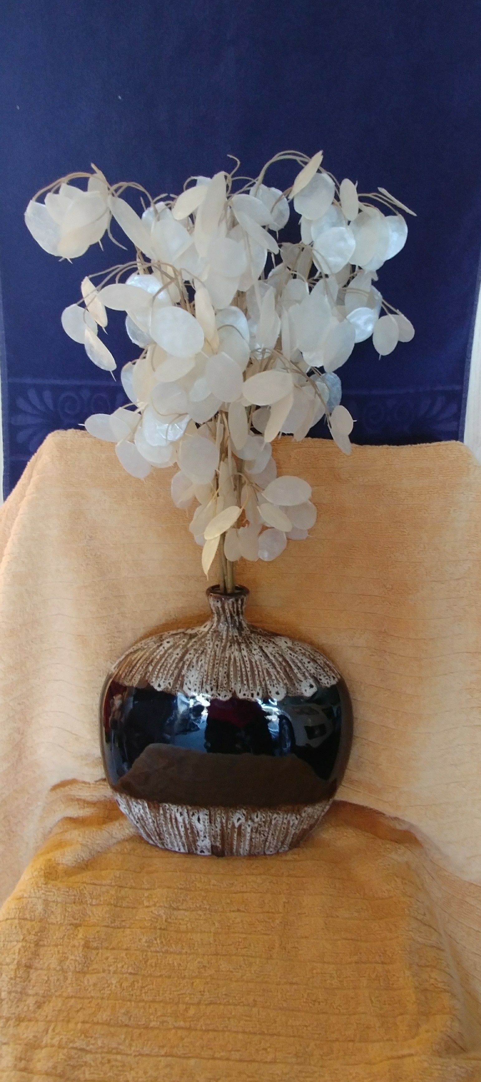 Ceramic vase filled with capiz shell stems