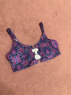 Soft crop top with vibrant floral print. Two front rings add a bold accent. Adjustable shoulder straps for a custom fit. Stretch fabric for comfort du