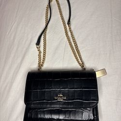Coach Klare Crossbody bag in black crocodile-embossed leather with a gold chain strap.