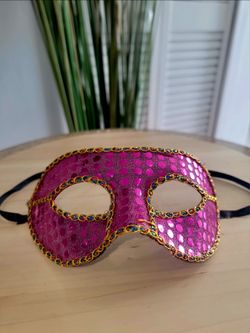 Venetian-style or masquerade mask with a plastic base and edges trimmed in braided fuchsia sequins; ideal for parties, proms, Halloween, etc.