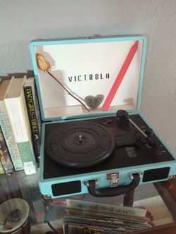 This is a Victrola portable suitcase record player in a turquoise blue finish