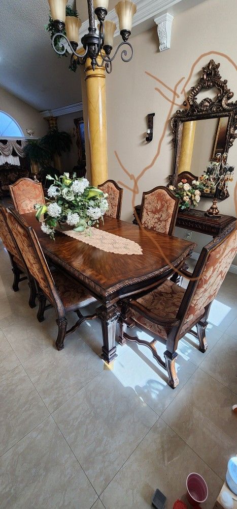 Dinning table, wall mirror, console table, canvas painting, and chandelier.