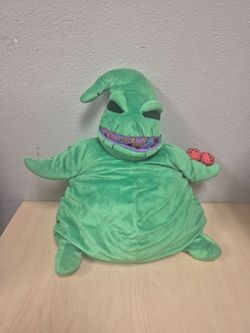Spirit Halloween The Nightmare Before Christmas Oogie Boogie green plush toy holding red dice.