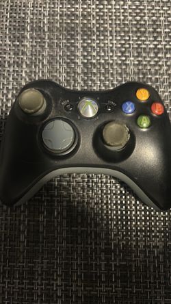 original Microsoft Xbox 360 Wireless Controller in black with heavily worn thumbsticks.