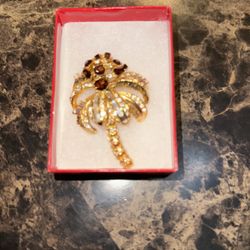 Vintage NOLAN MILLER gold-colored brooch with baguette glass crystals