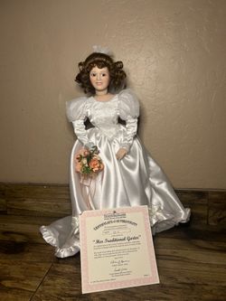 Doll comes with a white satin dress and flowers