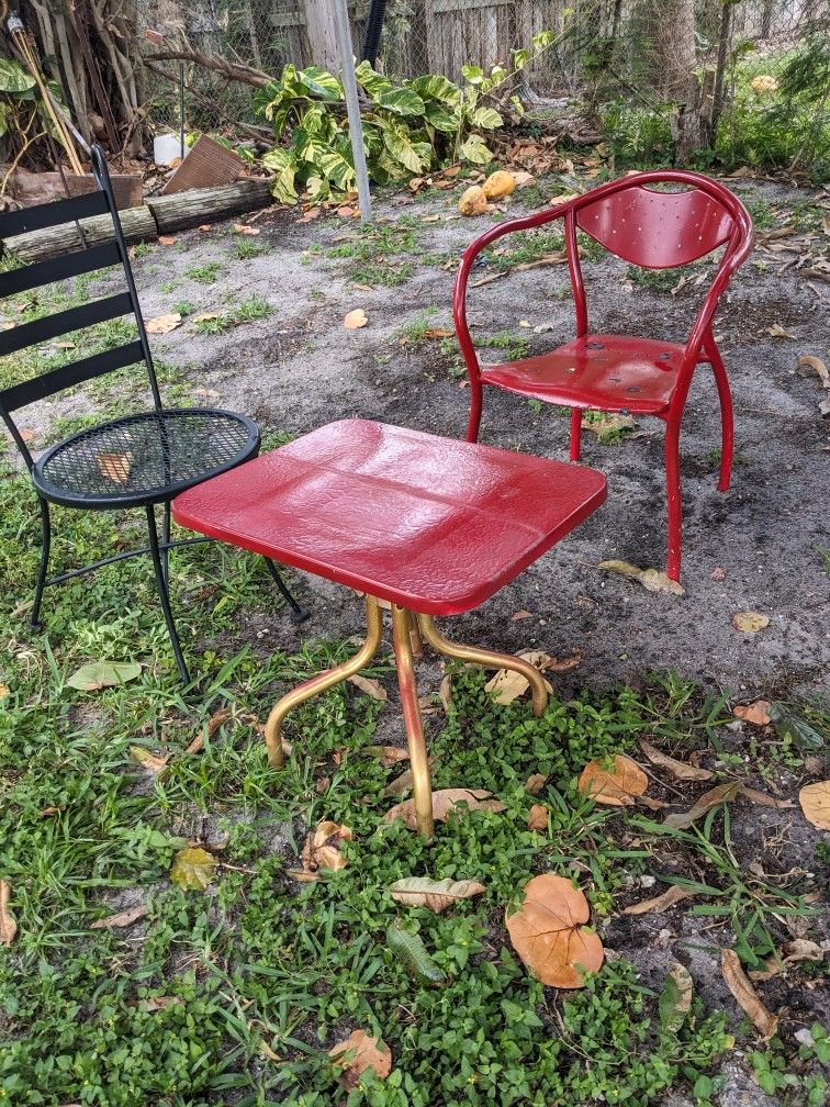 One Metal Table Two Metal Chairs One Red One Black