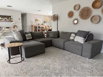 L shaped couch dark gray recliner with pillow and side table