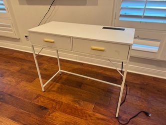 White writing desk with power outlets and usb.