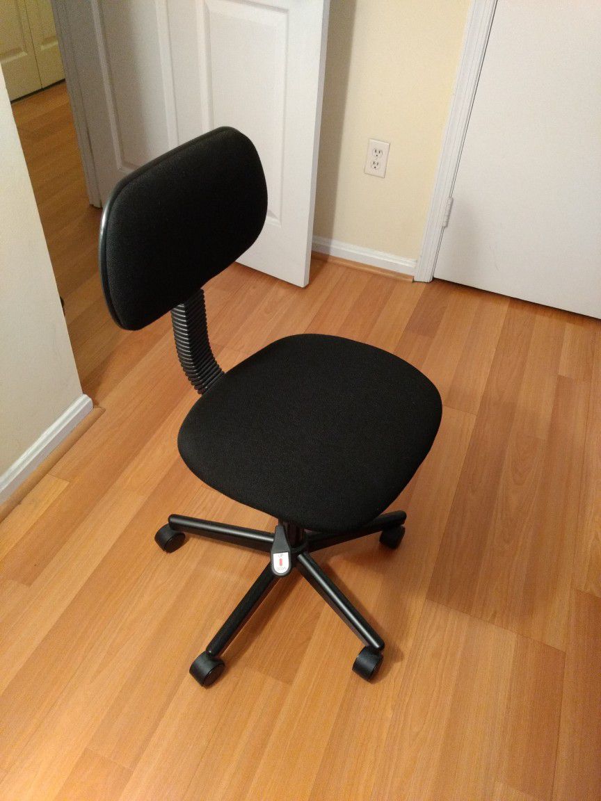Office chair and stand lamp with a desk.