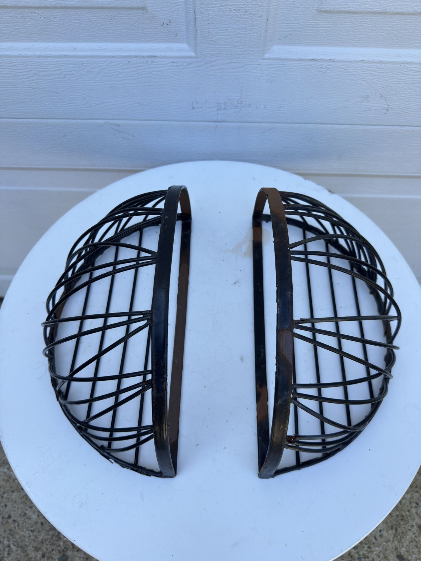 Two semi-circular iron flower pot stands