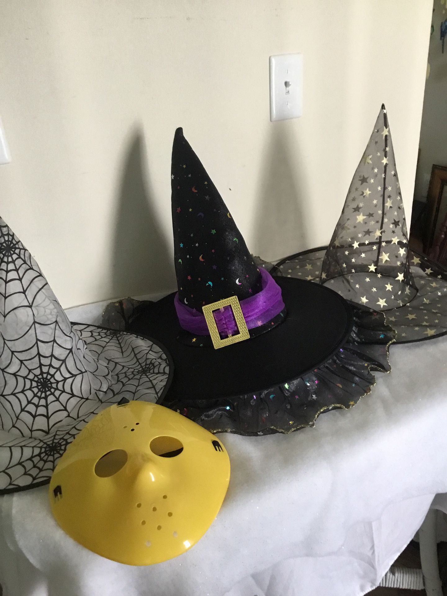 Three Halloween witches hats and one plastic scary mask