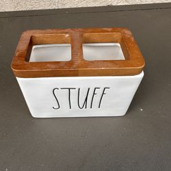 Rae Dunn "Stuff" ceramic holder with a wood trim lid. It is a popular collectible item often used as a toothbrush holder or for organizing m