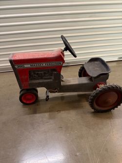 Vintage metal Massey Ferguson 390 pedal tractor has a red and grey finish