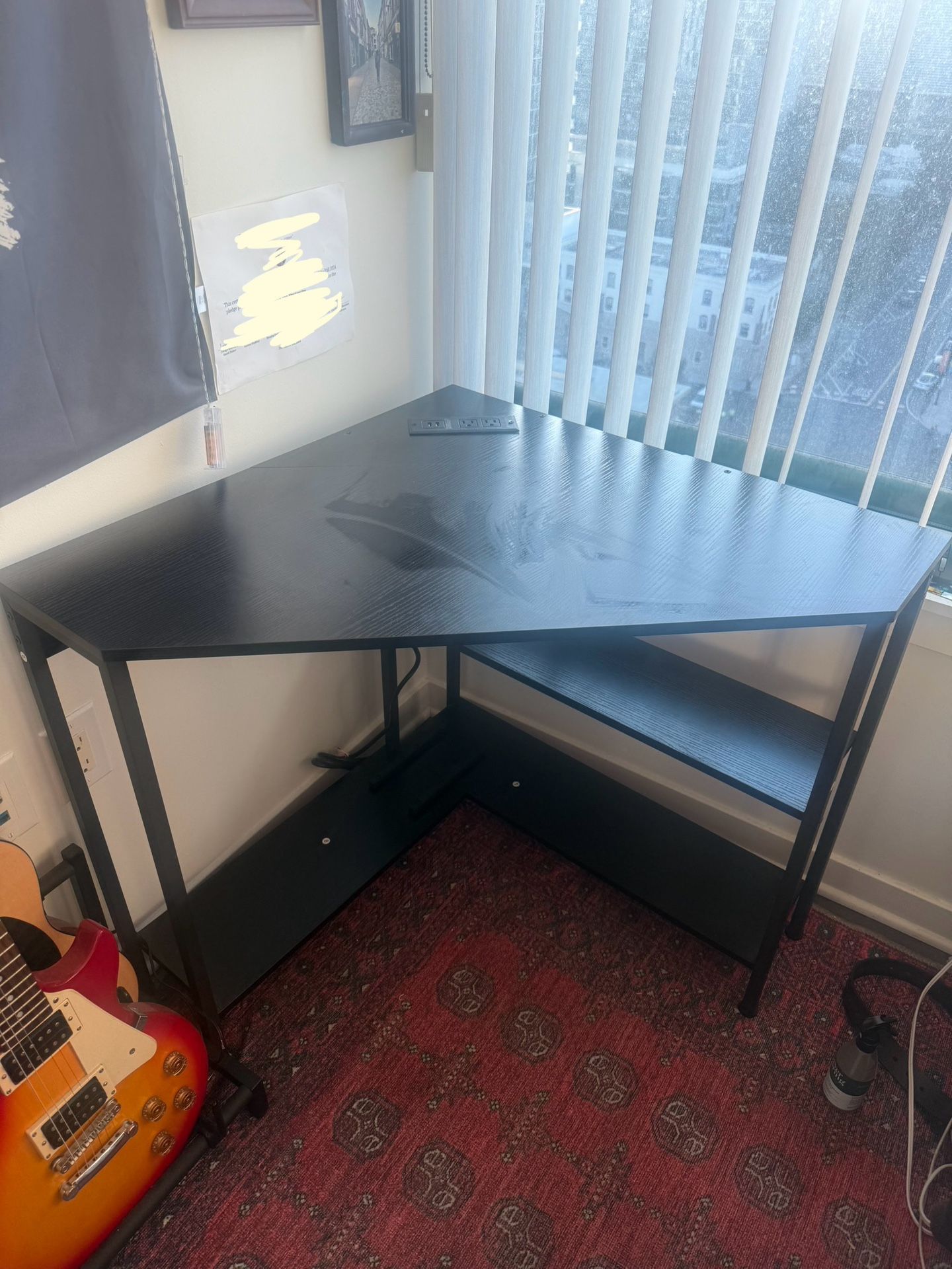 Black wooden corner desk with outlets