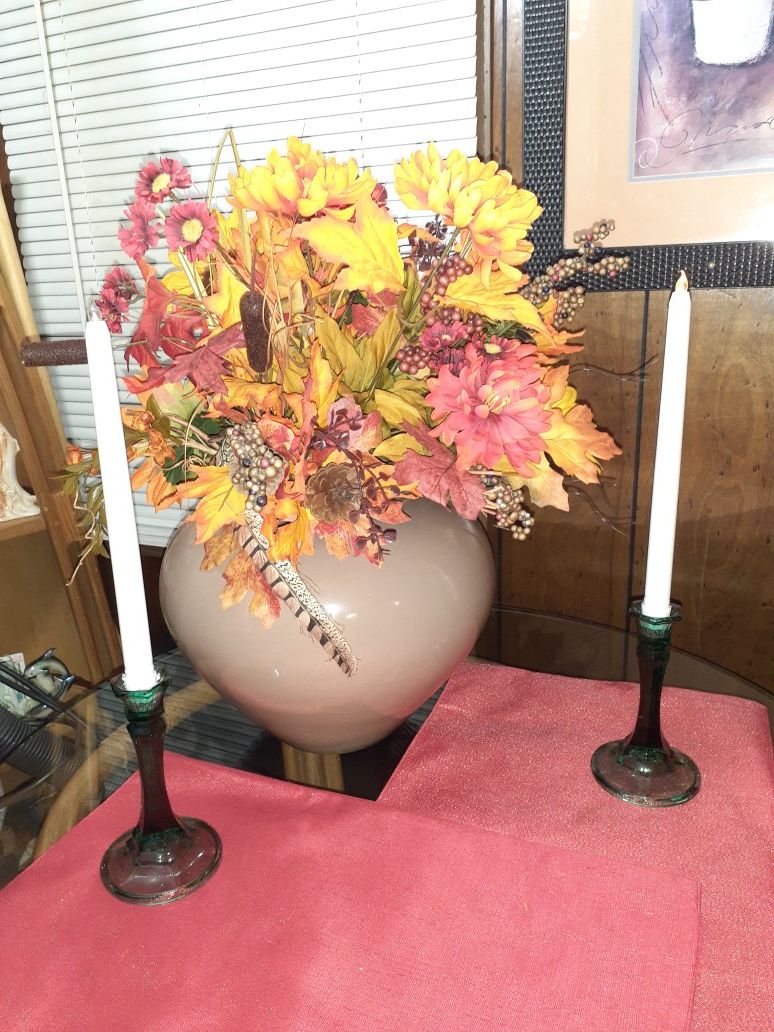 Artificial flowers in vase with two candle sticks