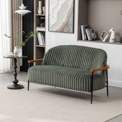 Green tufted upholstered two-seater sofa with iron legs